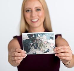 Veteran hold a picture of herself when she was deployed